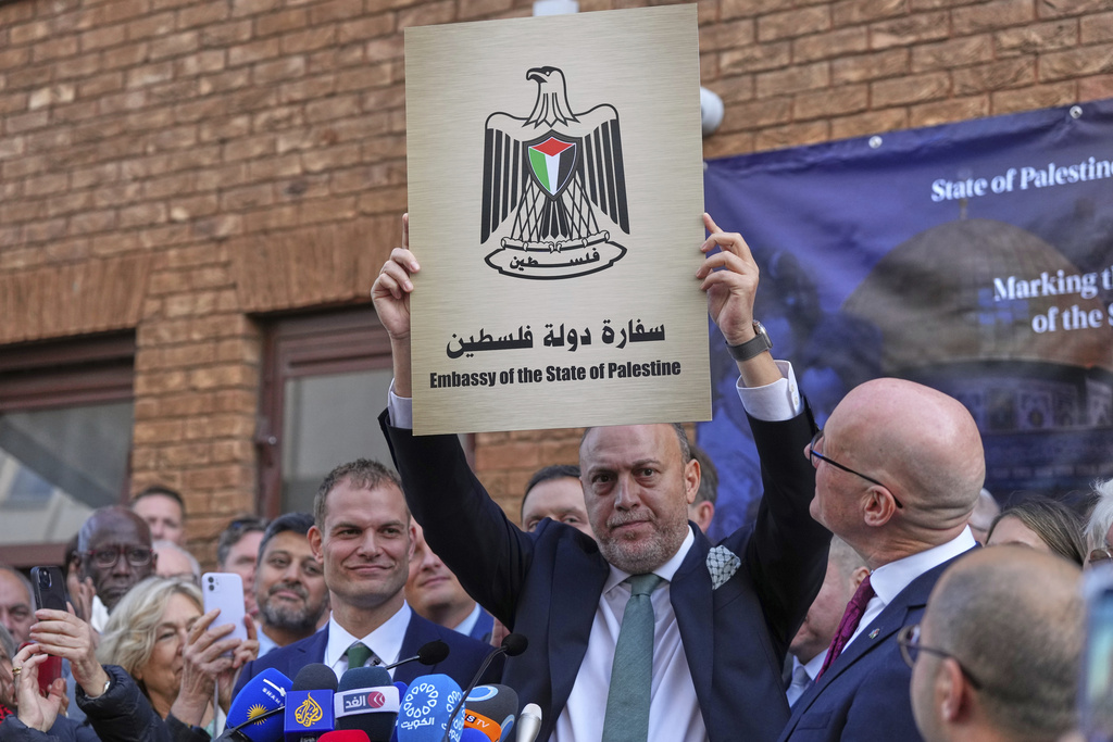 Husam S. Zomlot, Ambassador for the Palestinian Mission to the United Kingdom holds up a new sign during a Palestinian flag raising ceremony at the Palestinian Mission in London, Monday, Sept. 22, 2025.(AP Photo/Frank Augstein)