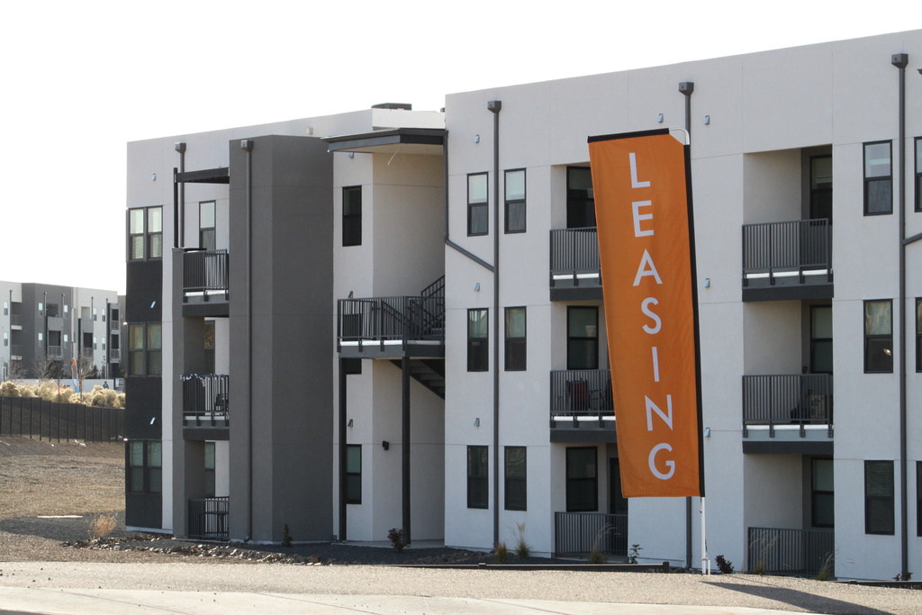 Signs advertise a new apartment complex in Santa Fe, New Mexico, on Wednesday, Nov. 26, 2025, where the city has adopted an updated minimum wage ordinance linked to fair market rent and consumer prices. (AP Photo/Susan Montoya Bryan)