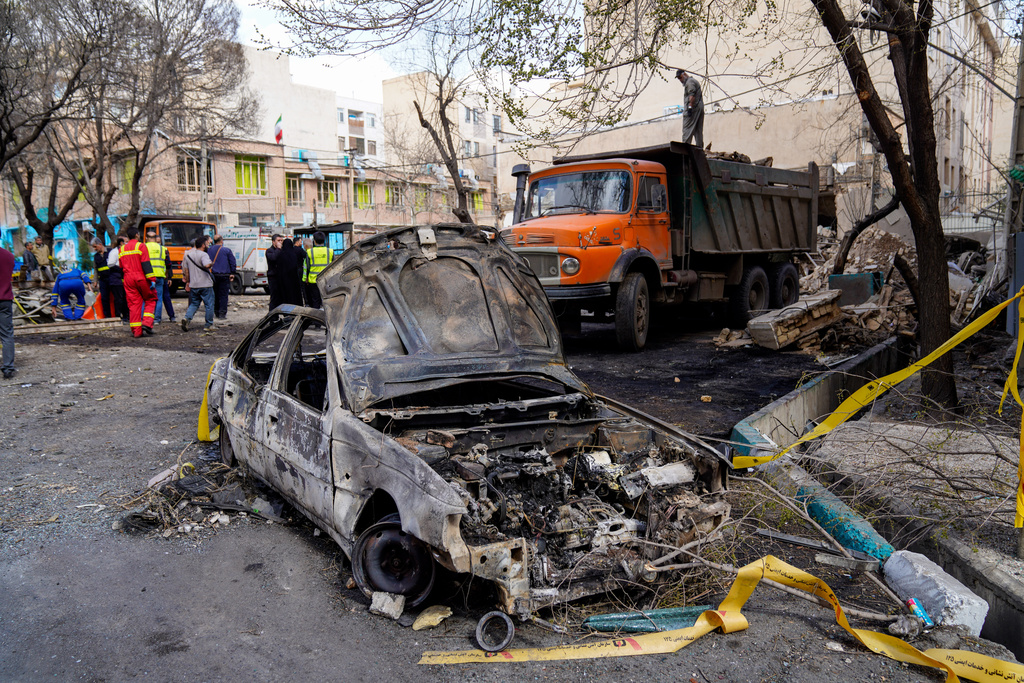 A damaged car remains on the ground in the aftermath of an Israeli-U.S. strike in Tehran, Iran, Saturday, Feb. 28, 2026. (AP Photo/Amir Kholousi/ISNA)