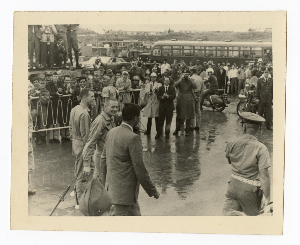 This 1966 photo taken by Ron McQueeney shows astronaut Neil Armstrong, center, waving to service members at Naha Air Base in Okinawa, Japan. (Ron McQueeney/Ohio History Connection via AP)