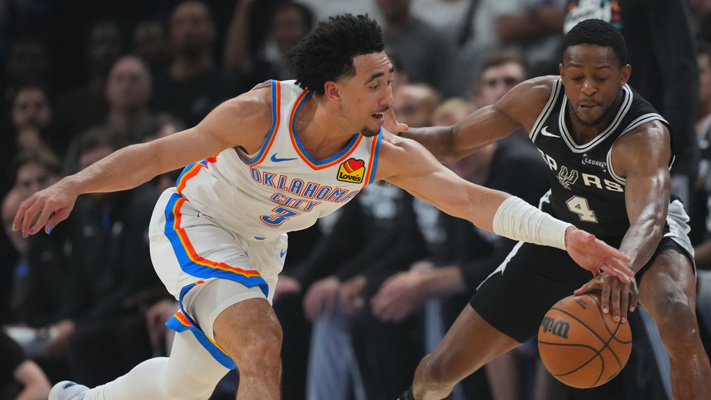 Oklahoma City Thunder guard Jared McCain (3) and San Antonio Spurs guard De'aaron Fox (4) vie for a loose ball in the first half of Game 5 in the Western Conference finals NBA basketball playoffs series, Tuesday, May 26, 2026, in Oklahoma City. (AP Photo/Julio Cortez)