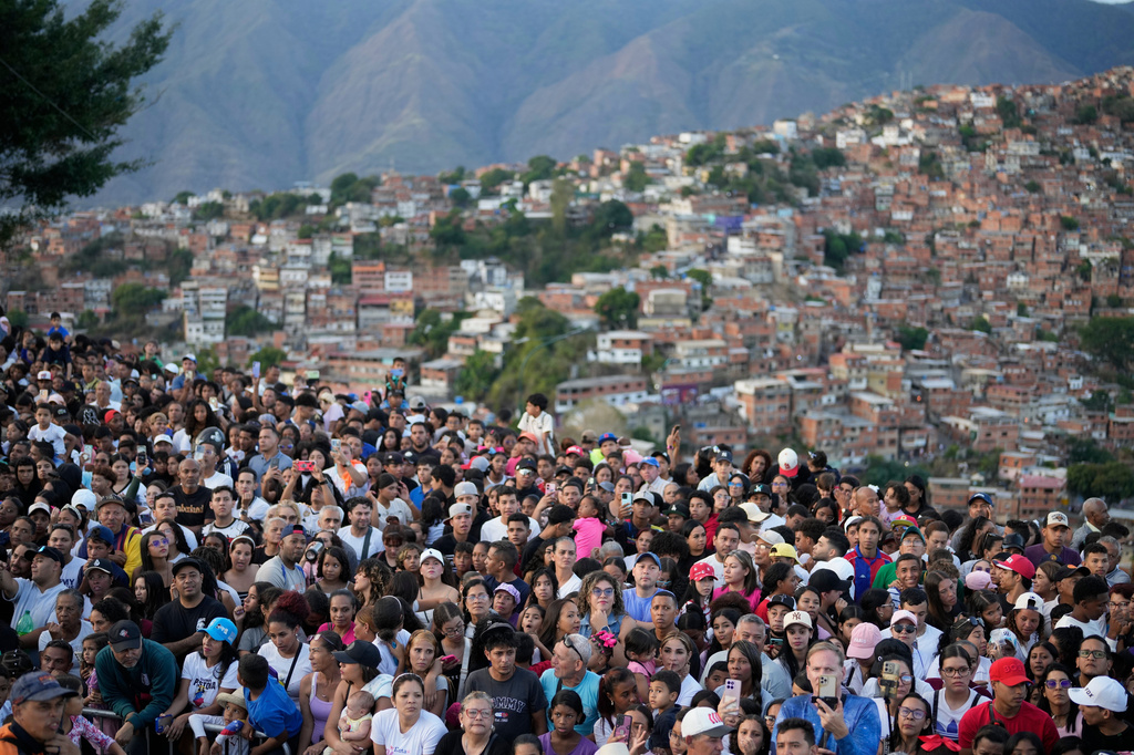 Faithful gather to watch a Way of the Cross reenactment as part of Holy Week celebrations in the Petare neighborhood of Caracas, Venezuela, Friday, April 3, 2026. (AP Photo/Ariana Cubillos)