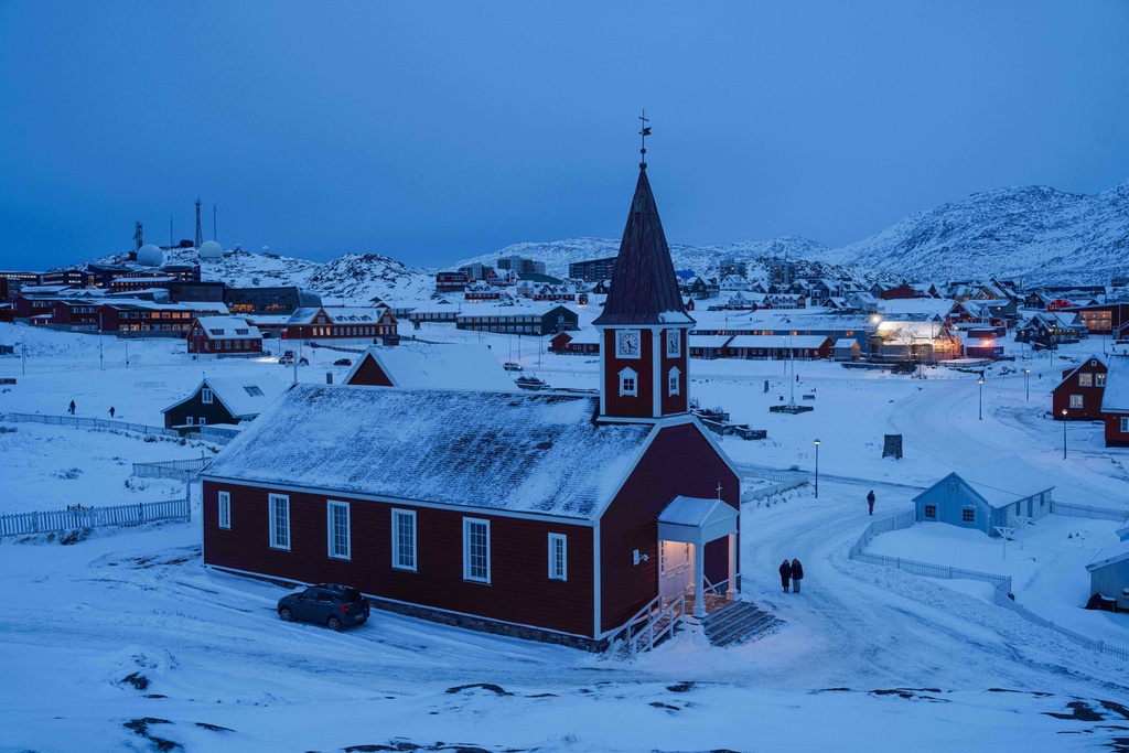 People walk near the church in Nuuk, Greenland, on Tuesday, Jan. 13, 2026. (AP Photo/Evgeniy Maloletka)