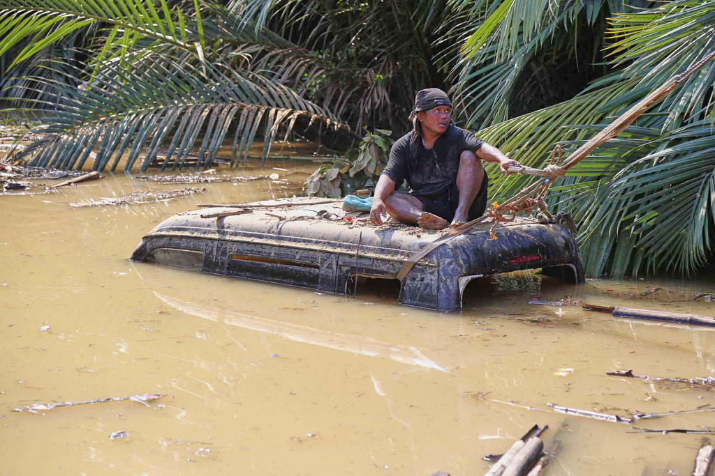 A man tries to retrieve a vehicle submerged in flood waters caused by Typhoon Kalmaegi in Liloan, Cebu province, central Philippines on Thursday, Nov. 6, 2025. (AP Photo/Jacqueline Hernandez)