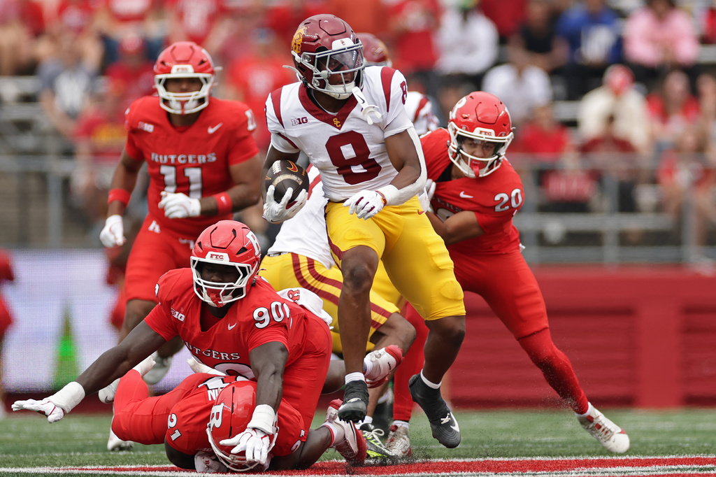 Southern California running back King Miller (8) runs past Rutgers defensive lineman Farell Gnago (90) during the first half of an NCAA college football game Saturday, Sept. 19, 2026, in Piscataway, N.J. (AP Photo/Adam Hunger)