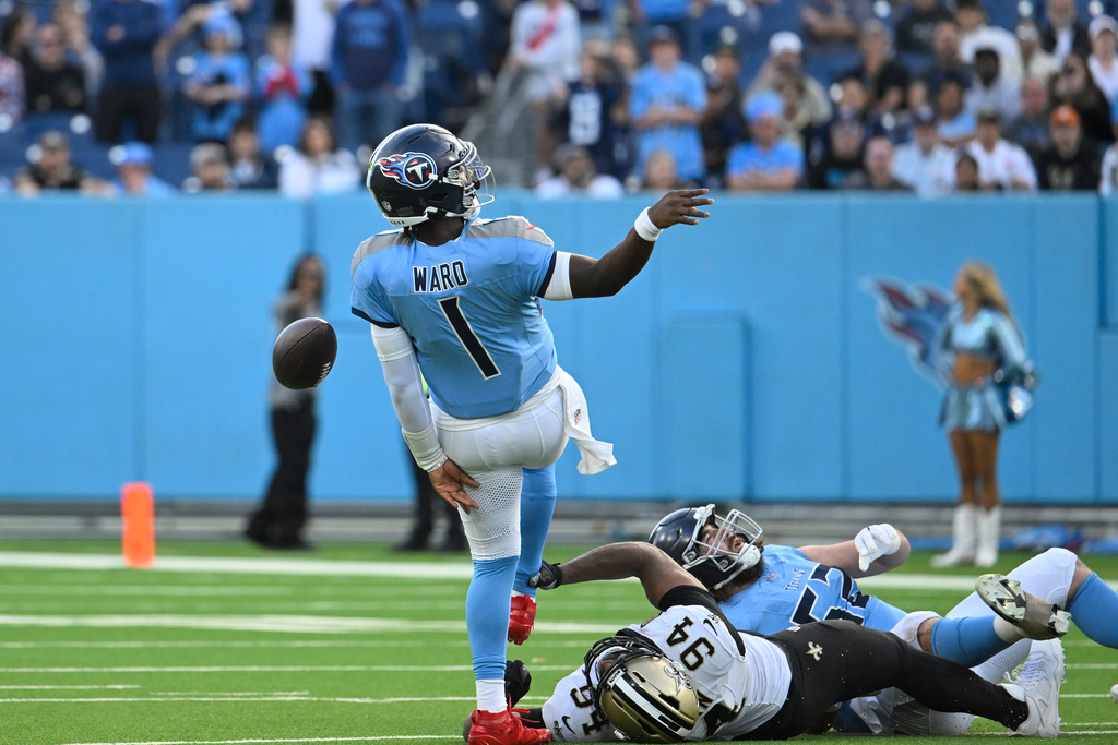 Tennessee Titans quarterback Cam Ward (1) is tripped up by New Orleans Saints defensive end Cameron Jordan (94) on the last play of the game, in the second half of an NFL football game, Sunday, Dec. 28, 2025, in Nashville, Tenn. (AP Photo/John Amis)