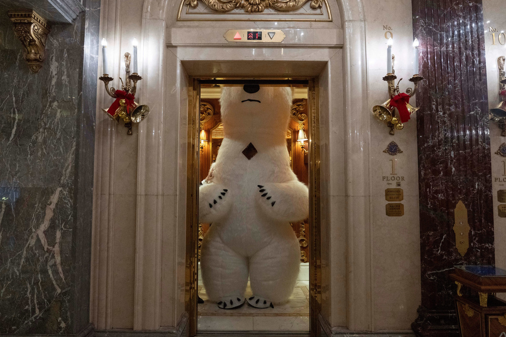 A polar bear mascot takes a ride in a lift during a break from entertaining guests on the eve of Christmas in Beijing, Wednesday, Dec. 24, 2025. (AP Photo/Ng Han Guan)