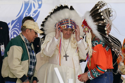 FILE - Pope Francis dons a headdress during a visit with Indigenous peoples at Maskwaci, the former Ermineskin Residential School, Monday, July 25, 2022, in Maskwacis, Alberta. (AP Photo/Eric Gay, File) FILE - Pope Francis dons a headdress during a visit with Indigenous peoples at Maskwaci, the former Ermineskin Residential School, Monday, July 25, 2022, in Maskwacis, Alberta. (AP Photo/Eric Gay, File)