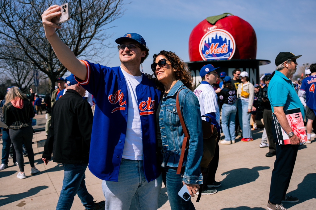 Fans take selfies as they arrive at Citi Field for an opening-day baseball game between the New York Mets and the Pittsburgh Pirates, Thursday, March 26, 2026, in New York. (AP Photo/Angelina Katsanis)