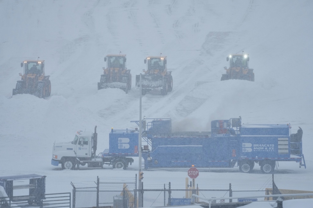 Airport crew plow snow during a winter storm in Philadelphia, Sunday, Jan. 25, 2026. (AP Photo/Matt Rourke)