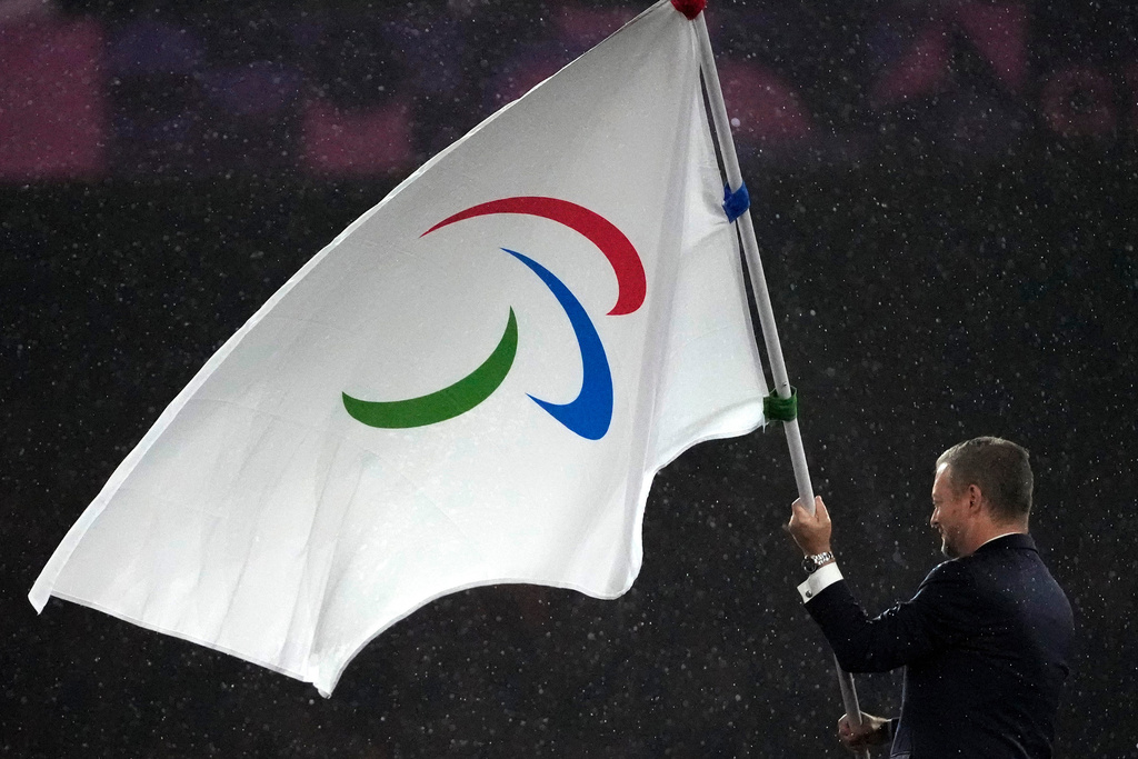 FILE - President of the International Paralympic Committee Andrew Parsons passes the Paralympic flag to Mayor of Los Angeles Karen Bass, not in photo, after receiving it from Mayor of Paris Anne Hidalgo, not in photo, during the closing ceremony of the 2024 Paralympics, Sunday, Sept. 8, 2024, in Paris, France. (AP Photo/Michel Euler, File)