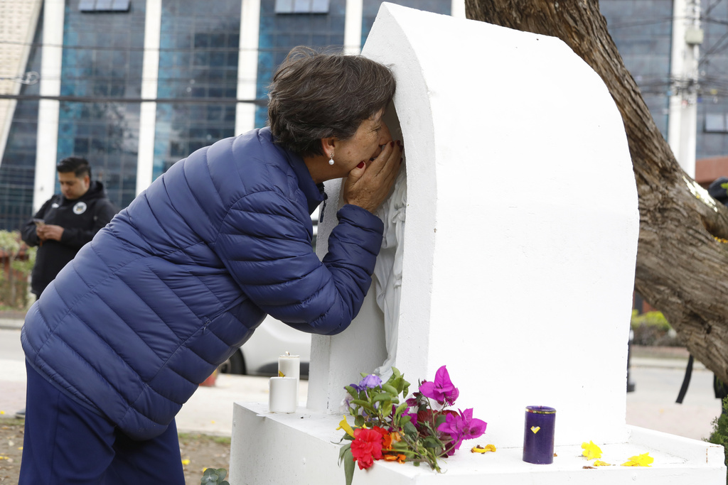 A woman prays at an altar built at the site where opposition Sen. and presidential hopeful Miguel Uribe was shot during a political rally, after the announcement of his death, in Bogota, Colombia, Monday, Aug. 11, 2025. (AP Photo/John Wilson Vizcaino)