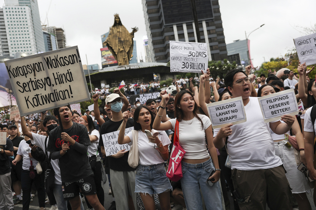 Protesters carry signs as they gather at the EDSA People Power Monument to rally against government corruption, in suburban Mandaluyong, east of Manila, Philippines, Sunday Sept. 21, 2025. (AP Photo/Basilio Sepe)