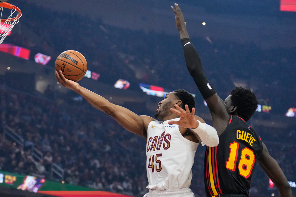 Cleveland Cavaliers guard Donovan Mitchell (45) shoots in front of Atlanta Hawks forward Mouhamed Gueye (18) in the first half of an NBA basketball game in Cleveland, Wednesday, April 8, 2026. (AP Photo/Sue Ogrocki)