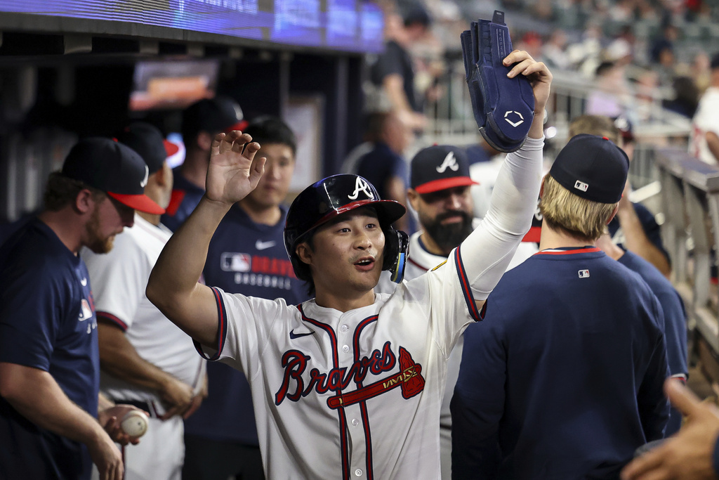 Atlanta Braves' Ha-Seong Kim, center, high-fives teammates in the dugout after scoring in the third inning of a baseball game against the Washington Nationals, Monday, Sept. 22, 2025, in Atlanta. (AP Photo/Colin Hubbard)