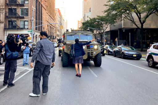A woman stands in front of an armored vehicle operated by federal agents on Lafayette Street as demonstrators follow along after an immigration sweep on Canal Street through Chinatown, Tuesday, Oct. 21, 2025, in New York. (AP Photo/Jake Offenhartz) A woman stands in front of an armored vehicle operated by federal agents on Lafayette Street as demonstrators follow along after an immigration sweep on Canal Street through Chinatown, Tuesday, Oct. 21, 2025, in New York. (AP Photo/Jake Offenhartz)