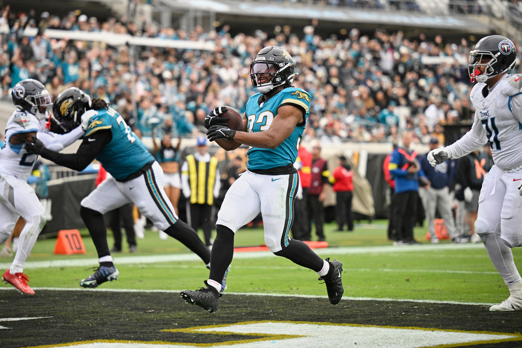 Jacksonville Jaguars running back Bhayshul Tuten (33) runs the ball into the end zone for a touchdown during the second half of an NFL football game against the Tennessee Titans, Sunday, Jan. 4, 2026, in Jacksonville, Fla. (AP Photo/Phelan M. Ebenhack)