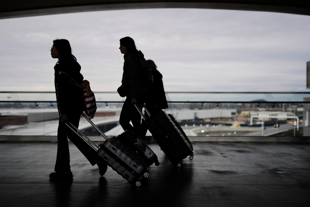 Travelers make their way through the Nashville International Airport, Tuesday, Nov. 25, 2025, in Nashville, Tenn. (AP Photo/George Walker IV)