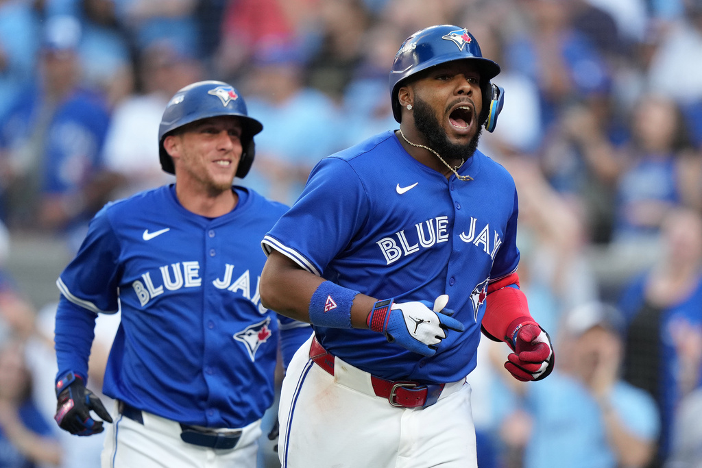 Toronto Blue Jays' Vladimir Guerrero Jr., right, rounds the bases after hitting a grand slam off New York Yankees pitcher Will Warren (not shown) during the fourth inning of Game 2 of baseball's American League Division Series in Toronto, Sunday, Oct. 5, 2025. (Nathan Denette/The Canadian Press via AP)