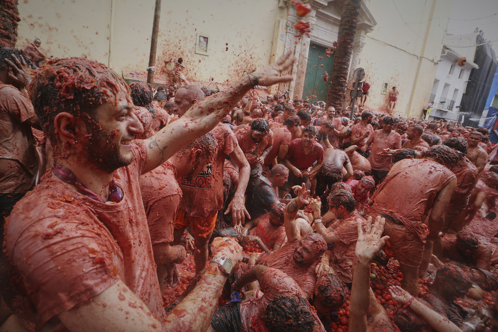 Revelers throw tomatoes at each other during the annual "Tomatina" tomato fight fiesta, in the village of Bunol near Valencia, Spain, Wednesday, Aug. 27, 2025. (AP Photo/Alberto Saiz)