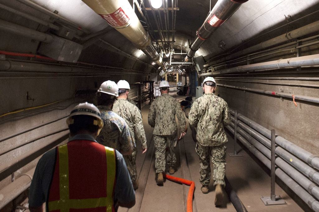 FILE - In this photo provided by the U.S. Navy, Rear Adm. John Korka, Commander, Naval Facilities Engineering Systems Command (NAVFAC), and Chief of Civil Engineers, leads Navy and civilian water quality recovery experts through the tunnels of the Red Hill Bulk Fuel Storage Facility, near Pearl Harbor, Hawaii, on Dec. 23, 2021. (Mass Communication Spc. 1st Class Luke McCall/U.S. Navy via AP, File)