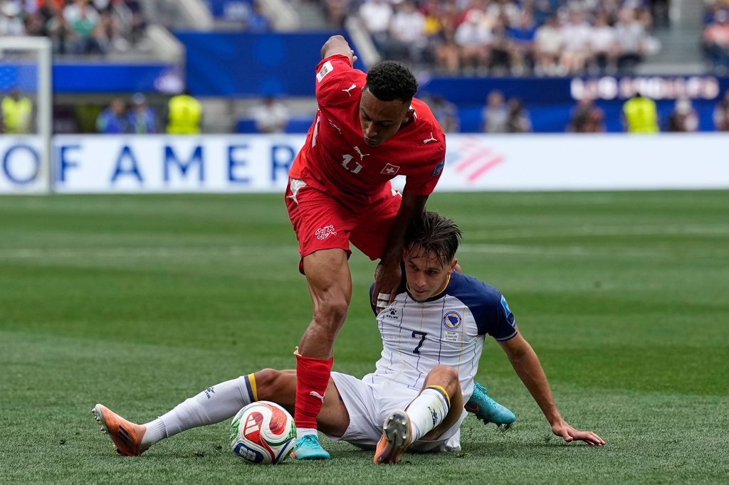 Switzerland's Dan Ndoye (11) battles for the ball with Bosnia's Amar Dedic (7), right, during the World Cup Group B soccer match between Switzerland and Bosnia in Inglewood, Calif, near Los Angeles, Thursday, June 18, 2026. (AP Photo/Gregory Bull)