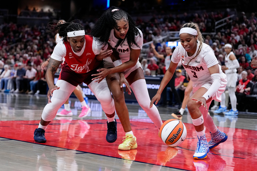 Atlanta Dream guard Jordin Canada (3) picks up a loose ball in front of Indiana Fever forward Myisha Hines-Allen (2) and Atlanta Dream forward Angel Reese (5) in the first half of a WNBA basketball game in Indianapolis, Thursday, June 18, 2026. (AP Photo/Michael Conroy)