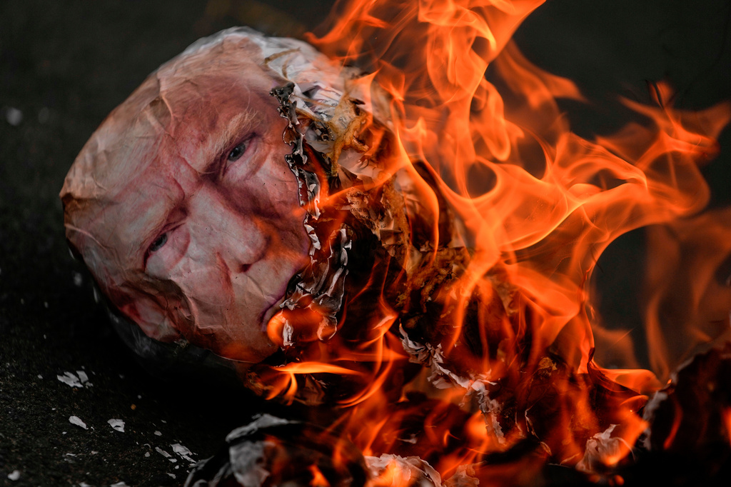 FILE - An effigy of President Donald Trump goes up in flames during an International Workers' Day march marking May Day in Panama City, May 1, 2026. (AP Photo/Matias Delacroix, File)