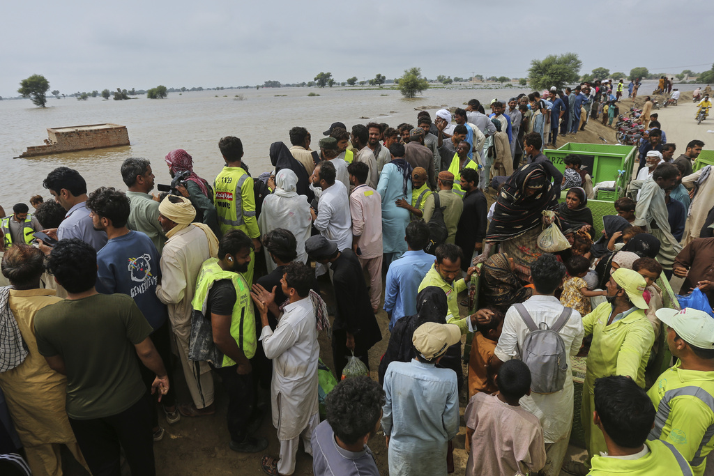 Volunteers help villagers on the higher ground after they are evacuated by rescue workers from a flooded area following raising water level in rivers, in Jalalpur Pirwala, in Multan district, Pakistan, Monday, Sept. 8, 2025. (AP Photo/Asim Tanveer)