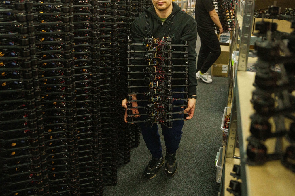 An engineer carries FPV drones of "General Cherry" company at the workshop in Ukraine, on Dec. 4, 2025. (AP Photo/Evgeniy Maloletka)