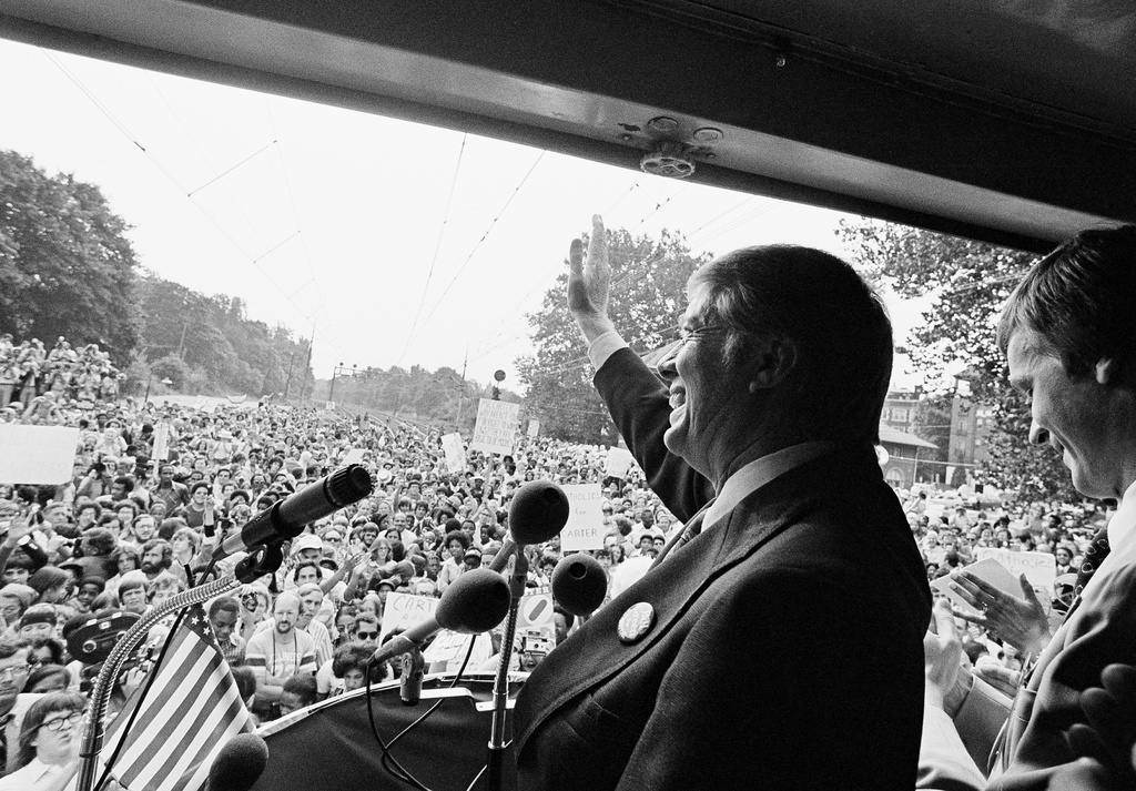 FILE - Presidential candidate Jimmy Carter waves from the rear of a train to a crowd of supporters in Philadelphia, Pa., Sept. 20, 1976. Carter made the stop during his 14-hour three-state whistle stop campaign. (AP Photo/Jack Thornell, File)