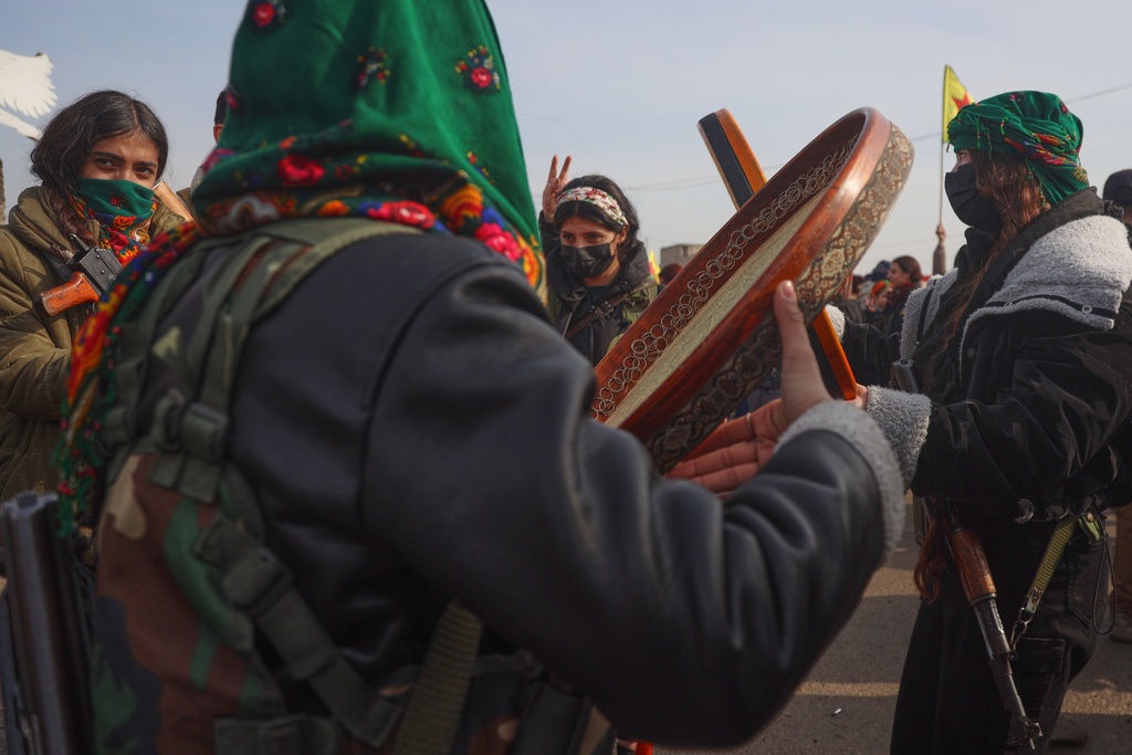 Kurdish fighters with the Syrian Democratic Forces (SDF) dance as they are cheered by local residents ahead of the end of a four-day truce with the Syrian government in Hassakeh, northeastern Syria, Saturday, Jan. 24, 2026. (AP Photo/Baderkhan Ahmad)