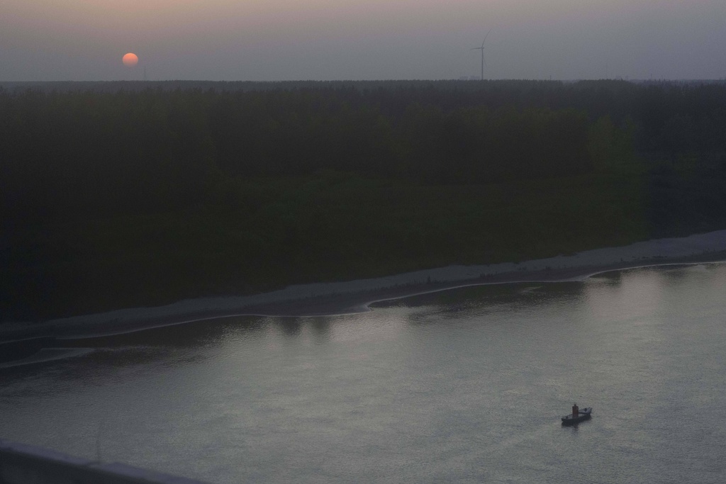 A boat is seen along the Yangtze River as the sun sets near Yichang in central China's Hubei province on June 16, 2025. (AP Photo/Ng Han Guan)
