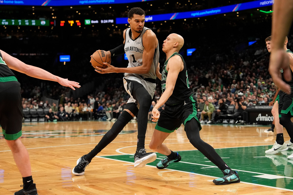 San Antonio Spurs forward Victor Wembanyama (1) drives to the basket against Boston Celtics guard Derrick White (9) during the second half of an NBA basketball game Saturday, Jan. 10, 2026, in Boston. (AP Photo/Robert F. Bukaty)