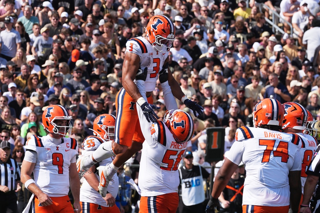 Illinois running back Kaden Feagin (3) celebrates a touchdown run with offensive lineman Melvin Priestly (58) during the first half of an NCAA college football game against Purdue, Saturday, Oct. 4, 2025, in West Lafayette, Ind. (AP Photo/Darron Cummings)