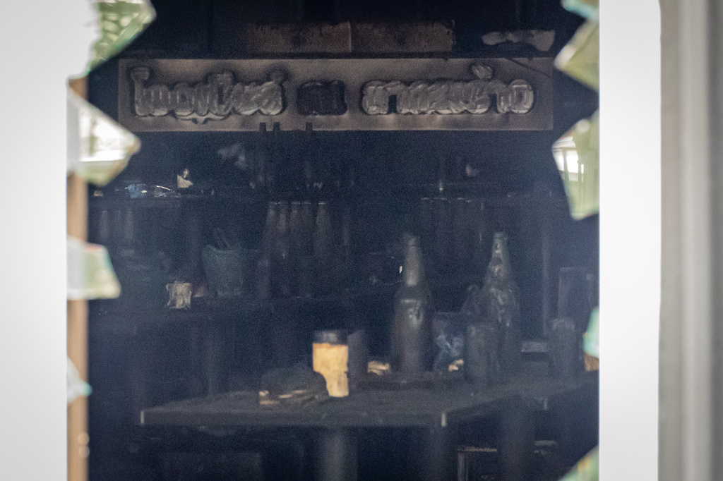 Bottles are seen sitting atop burned tables inside the music bar where a fire killed a number of people in Bangkok, Thailand, Tuesday, July 14, 2026. (AP Photo/Wason Wanichakorn)