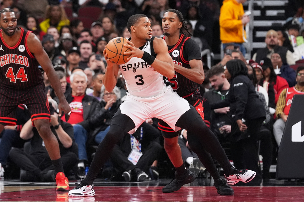 San Antonio Spurs forward Keldon Johnson (3) drives as Chicago Bulls forward Julian Phillips guards during the first half of an NBA basketball game in Chicago, Monday, Nov. 10, 2025. (AP Photo/Nam Y. Huh)