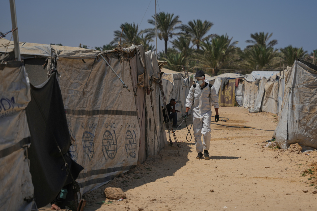 A municipal worker sprays pesticide as part of an initiative to combat rodents and insects at a tent camp for displaced Palestinians in Deir al-Balah, central Gaza Strip, Wednesday, July 22, 2026. (AP Photo/Abdel Kareem Hana)