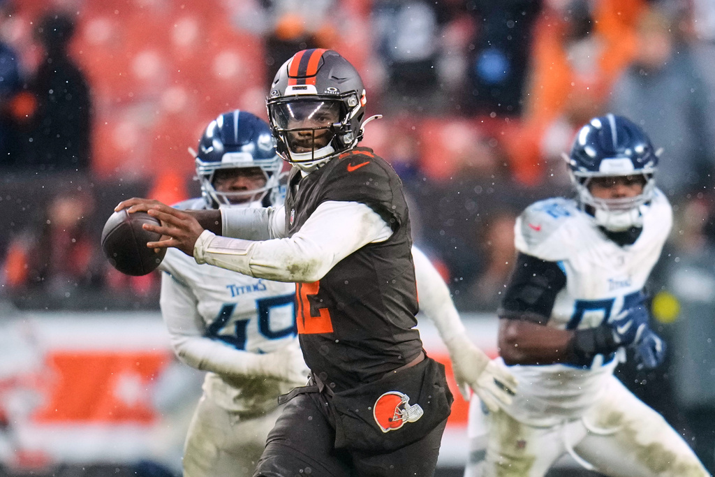 Cleveland Browns quarterback Shedeur Sanders (12) throws a pass under pressure from Tennessee Titans defenders in the second half of an NFL football game in Cleveland, Sunday, Dec. 7, 2025. (AP Photo/Sue Ogrocki)