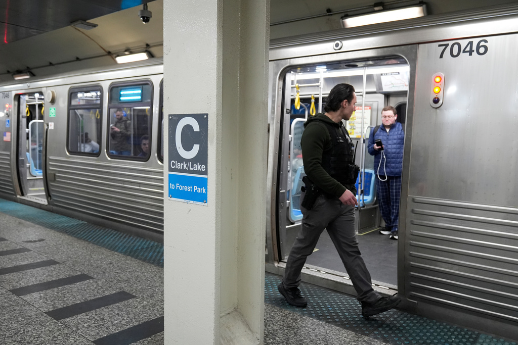 A Chicago police officer patrols the Clark Street and Lake Street Blue Line stop where a man doused a woman in liquid and set her on fire on the train Monday night, Tuesday, Nov. 18, 2025, in Chicago. (AP Photo/Erin Hooley)