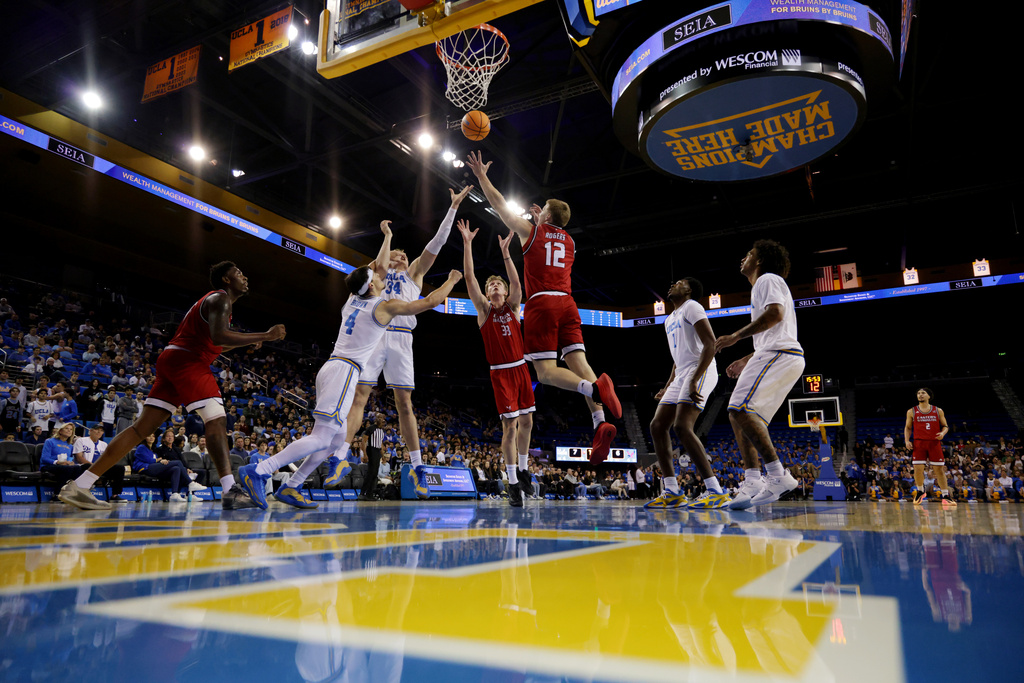 Eastern Washington guard Straton Rogers (12) lays up the ball as UCLA guard Jamar Brown (4) and forward Tyler Bilodeau (34) defend during the first half of an NCAA college basketball game Monday, Nov. 3, 2025, in Los Angeles. (AP Photo/Ethan Swope)