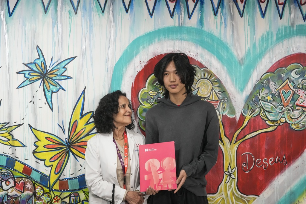 U.S. influencer Ethan Guo, right, stands with Marcela Zubieta, director of "Fundacion Nuestros Hijos" at an event about his donation to children's cancer rehabilitation programs in Santiago, Chile, Tuesday, Sept. 9, 2025. (AP Photo/Esteban Felix)