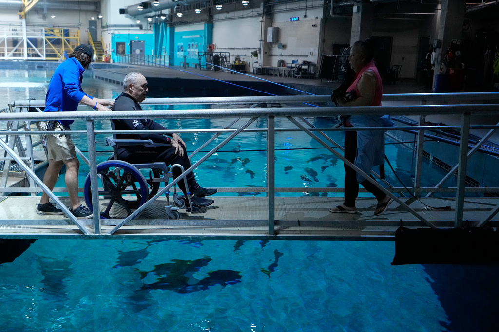 Quentin Collins, with the Wounded Warrior Project, is taken on a ramp before swimming at the Georgia Aquarium as a part of the Veterans Immersion Program, Wednesday, May 6, 2026, in Atlanta. (AP Photo/Brynn Anderson)
