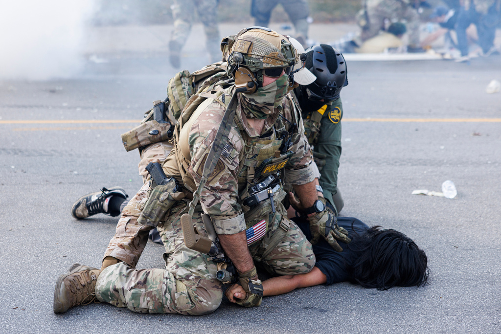 Federal officers hold down a protestor in the Brighton Park neighborhood of Chicago, on Saturday, Oct. 4, 2025, after protesters learned that U.S. Border Patrol shot a woman Saturday morning on Chicago's Southwest Side. (Anthony Vazquez/Chicago Sun-Times via AP)