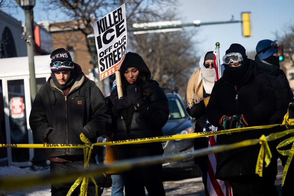 People gather at the site where a federal officer shot and killed 37-year-old Alex Pretti in Minneapolis on Saturday, Jan. 24, 2026. (Ben Hovland/Minnesota Public Radio via AP)