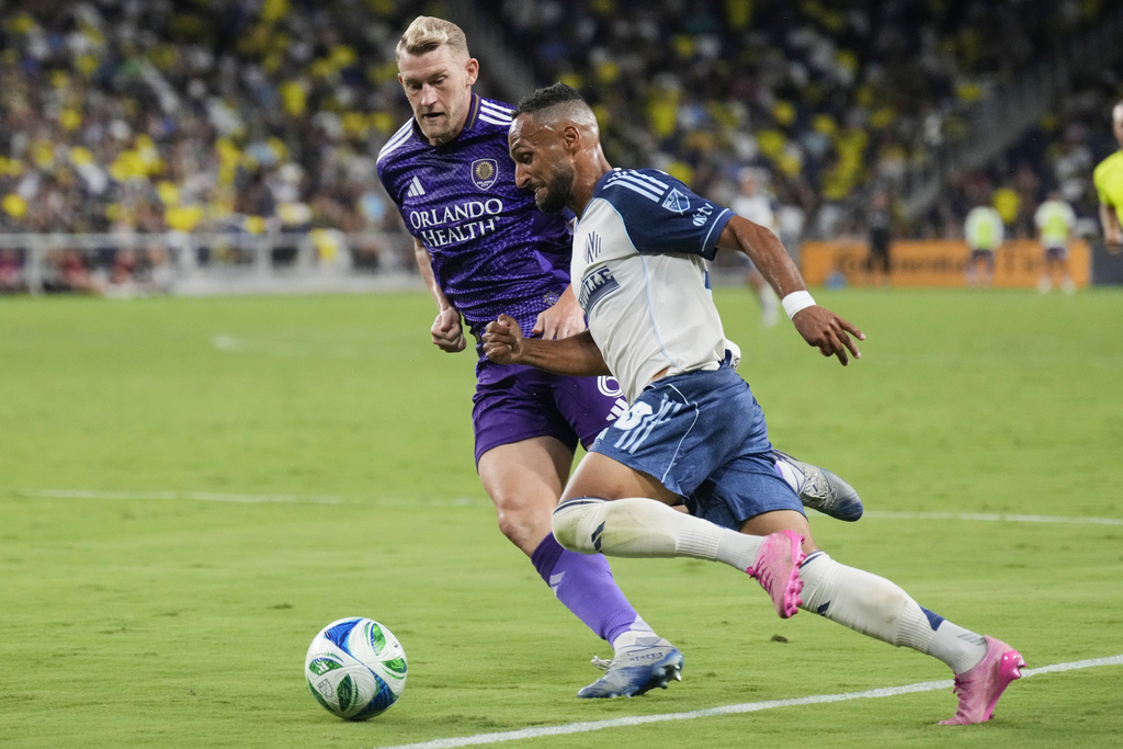 Nashville SC midfielder Hany Mukhtar, right, moves the ball past Orlando City defender Robin Jansson, left, during the second half of an MLS soccer match Saturday, Aug. 23, 2025, in Nashville, Tenn. (AP Photo/George Walker IV)