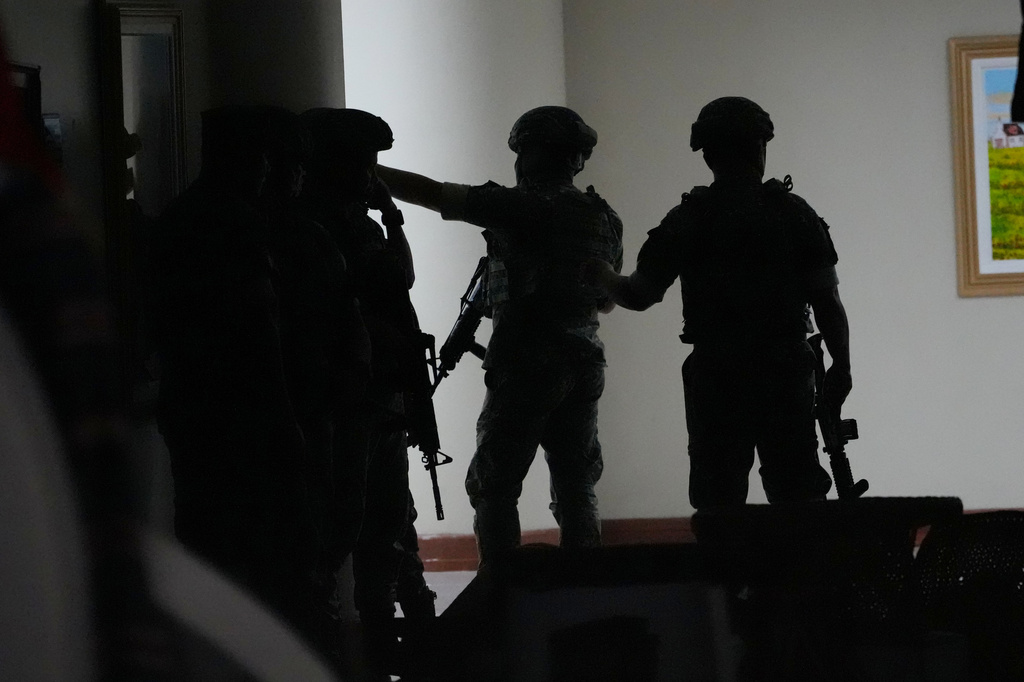 Philippine troopers exchange fire along a hallway at the Philippine Senate in Pasay, Philippines on Wednesday May 13, 2026. (AP Photo/Aaron Favila)