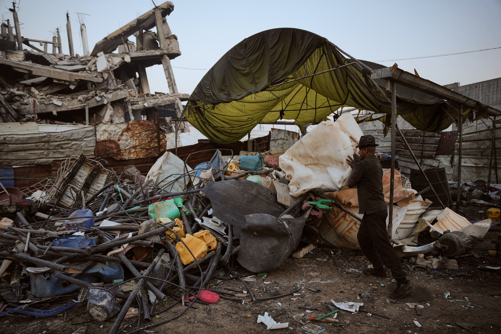 Hussein Abu Dahrouj 24 collects plastic to be used at a makeshift burner to extract fuel in Zawaida, central Gaza strip, Thursday, Nov. 20, 2025. (AP Photo/Abdel Kareem Hana)