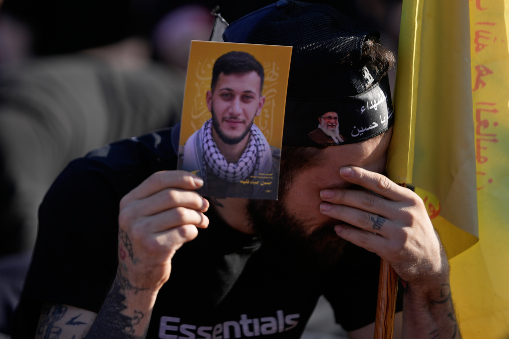 A man holds a portrait of his killed brother who was a Hezbollah fighter, as he mourns while listening to the death story of Imam Hussein during the holy day of Ashoura that commemorates the 7th century martyrdom of the Prophet Muhammad's grandson Hussein, in Dahiyeh, Beirut's southern suburbs, Lebanon, Friday, June 26, 2026. (AP Photo/Hussein Malla)