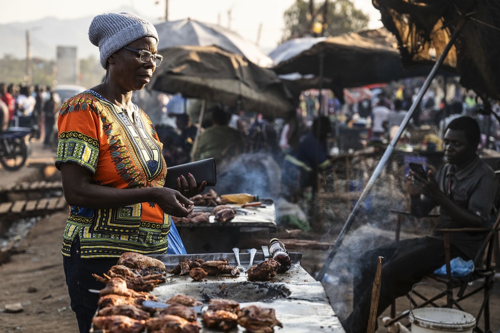 A woman buys food from a street vendor in Zomba, Malawi, Wednesday, Sept. 10, 2025. (AP Photo/Thoko Chikondi)
